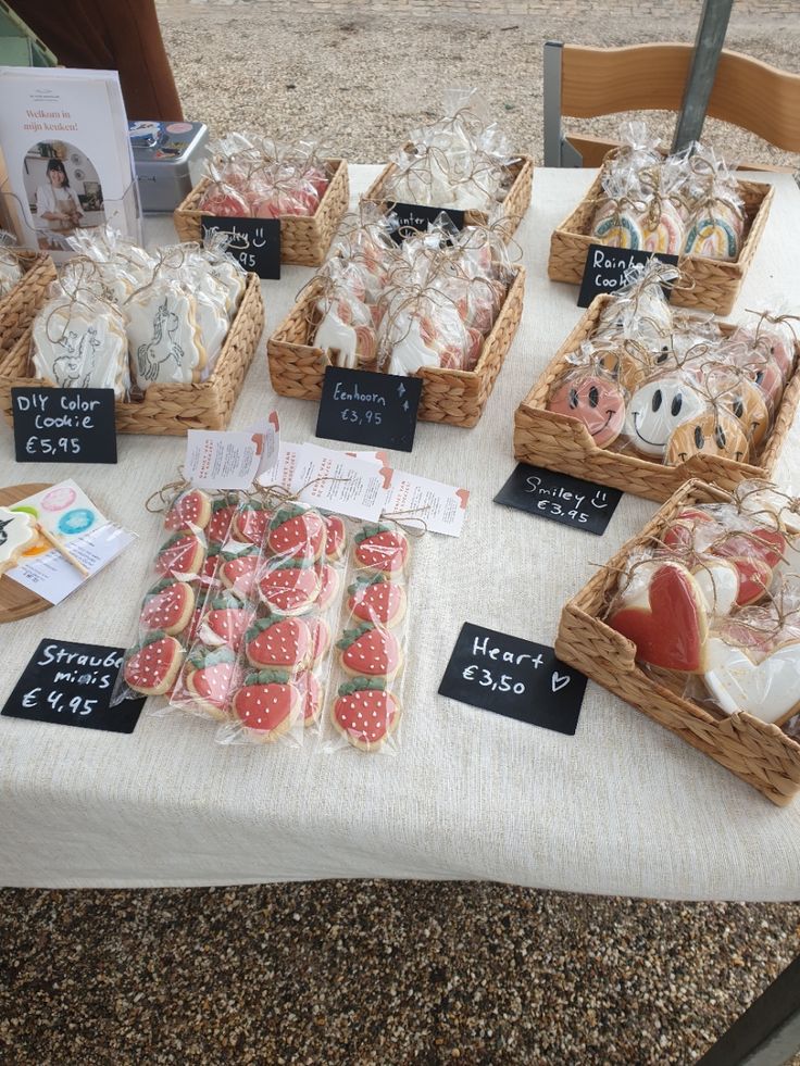 several baskets filled with food on top of a white table cloth covered table next to a wooden chair