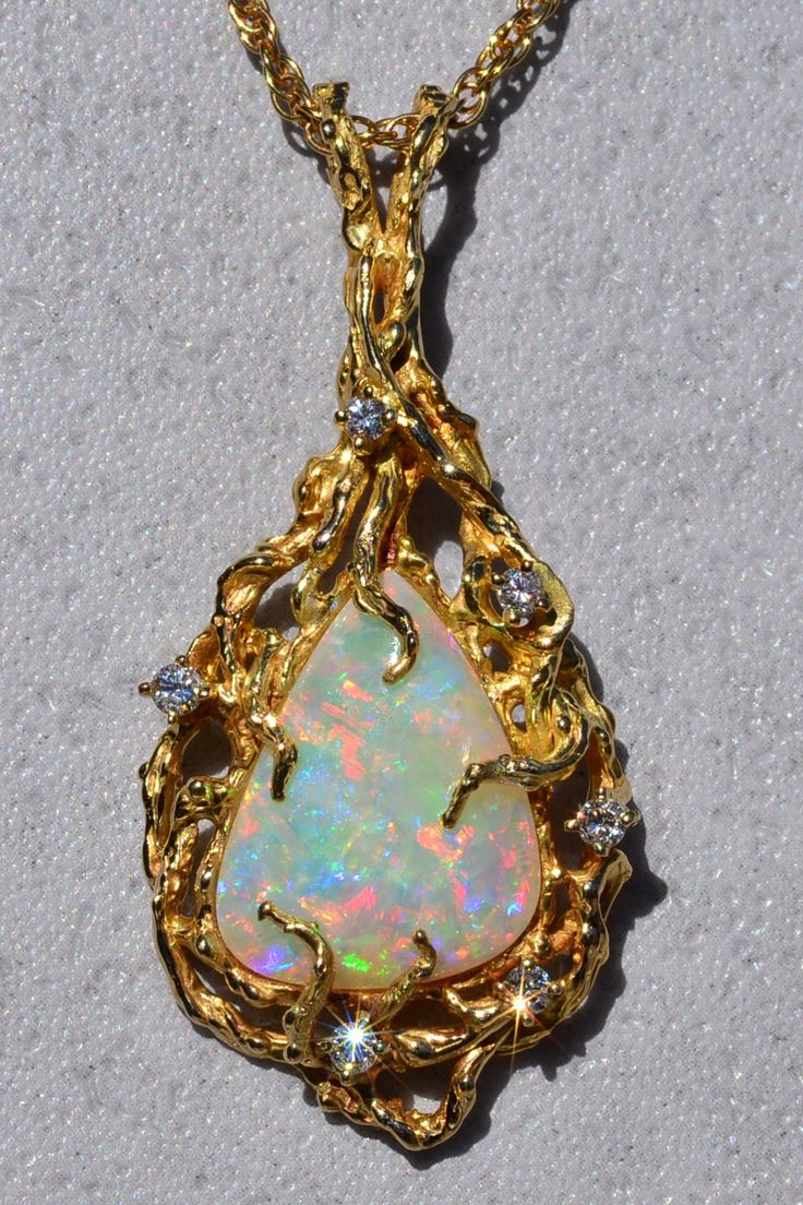 The Cicero: Ladies Brutalist Style 14K Yellow Gold Opal and Diamond Pendant. Beautifully handcrafted in 14 karat yellow gold is this 2-inch x 1-inch vintage pendant. The pendant is set with an approximate 20 x 15 x 4mm Australian opal that portrays excellent play of color. The pendant is also set with 0.30 carats of diamonds and features a large rabbit ear style bail. Purchase the pendant as is or inquire about purchasing a yellow gold chain to pair with this magnificent piece. Love this piece, Unique Yellow Gold Collectible Jewelry, Exquisite Yellow Gold Jewelry With Large Pendant, Exquisite Gold Jewelry Collectible, Unique Pear-shaped Gold Jewelry, Antique Gold Pear-shaped Jewelry, Exquisite Gold Necklace For Collectors, Handmade Yellow Gold Pear-shaped Jewelry, Antique Pear-shaped Gold Jewelry, Handmade Pear-shaped Yellow Gold Jewelry