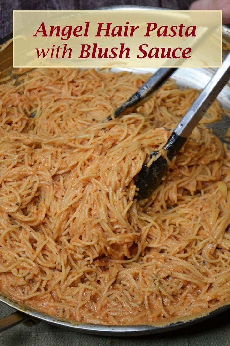 an angel hair pasta dish in a pan with two tongs sticking out of it