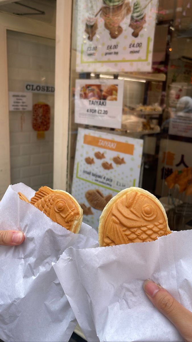 two people holding up some cookies in their hands