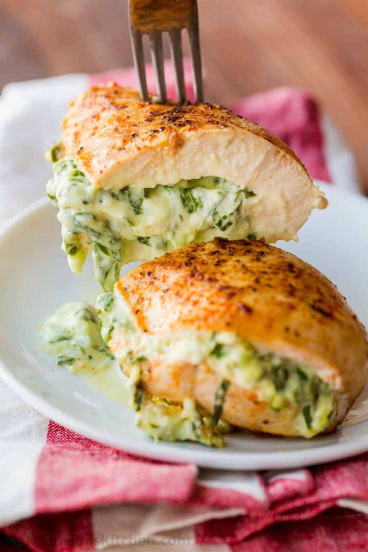 a white plate topped with chicken and broccoli covered in cheese