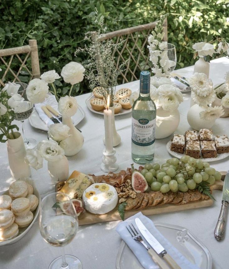 a table topped with lots of food and wine