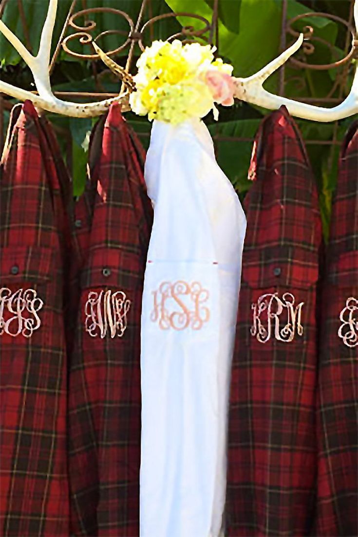 the antlers are decorated with monogrammed shirts and ties for brides to wear