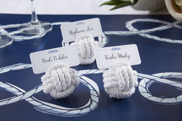 there are two white knotted balls on top of each other with name tags attached to them