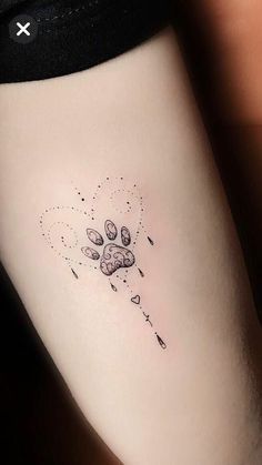 a small dog paw tattoo on the right side of the leg, with hearts and stars coming out of it