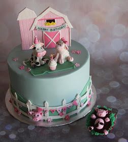 a birthday cake decorated with farm animals and a pink barn on the top, sitting next to a small cow figurine