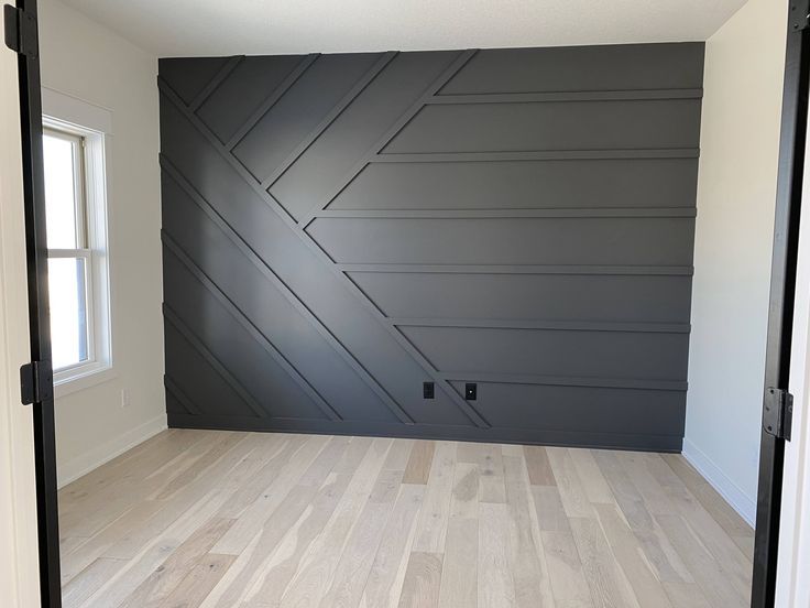 an empty room with wood floors and gray walls