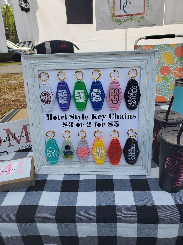 a table topped with lots of key chains on top of a black and white checkered table cloth