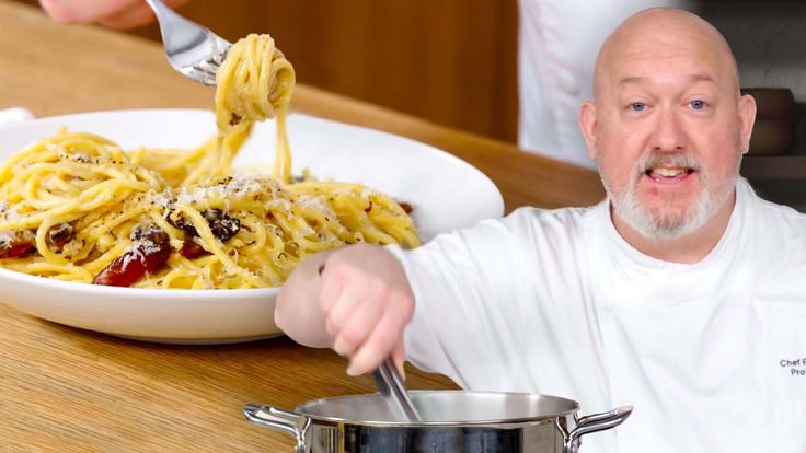 a man holding a ladle full of pasta in front of a plate of spaghetti