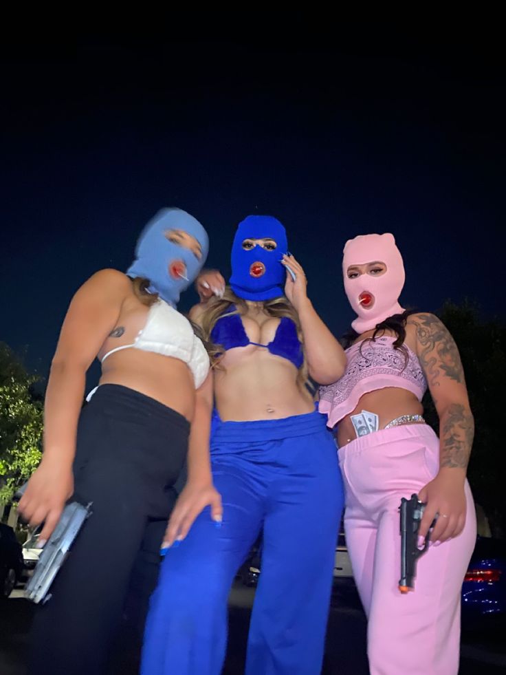 three women in costumes standing next to each other with their faces painted blue and pink