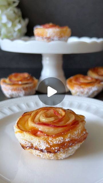 a pastry on a plate with other pastries in the background and an image of flowers