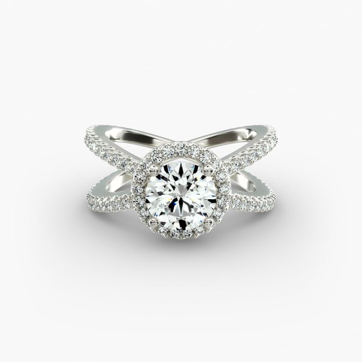 a white gold ring with diamonds on the band and an oval center stone in the middle