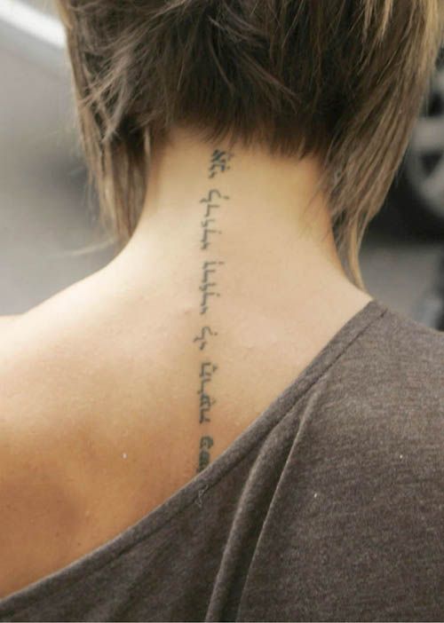 the back of a woman's neck with an inscription on it that reads,