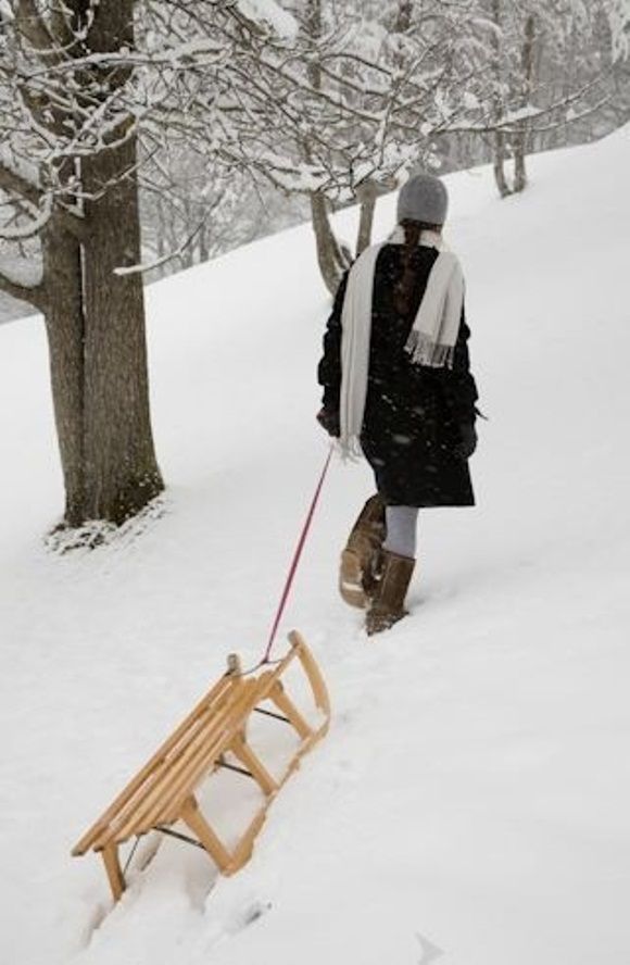 a person walking in the snow with a sled attached to their back, pulling a bench behind them