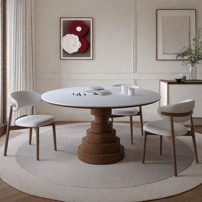 a white table with four chairs around it in a room next to a large window