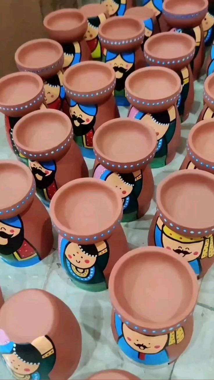 there are many clay pots with cartoon faces on them, all lined up in rows