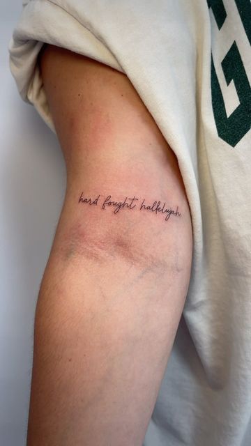 a person with a tattoo on their arm that says, hard right holidays in cursive writing