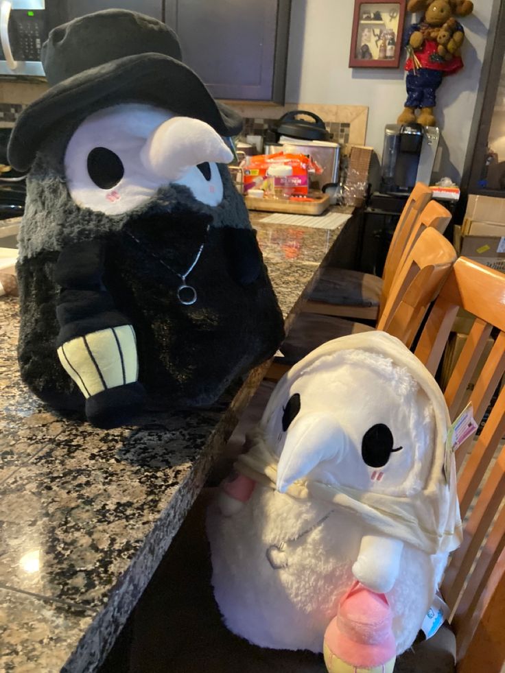 two stuffed animals sitting on top of a kitchen counter