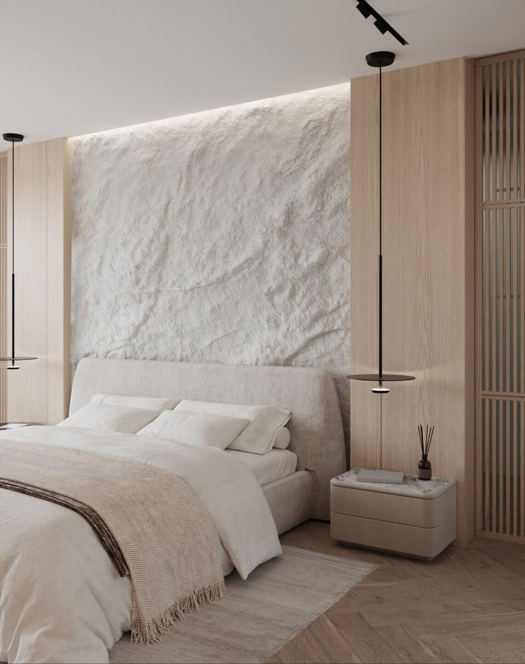 a large white bed sitting in a bedroom next to a tall wooden headboard on top of a wall