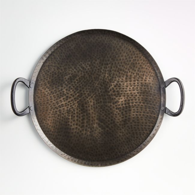 a round metal tray with handles on a white background