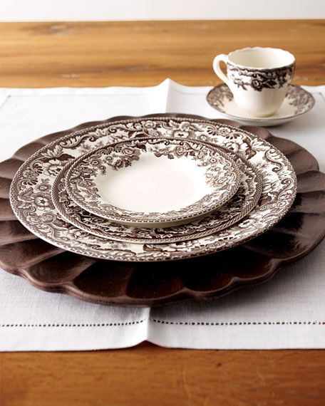 a white and brown place setting on top of a wooden table