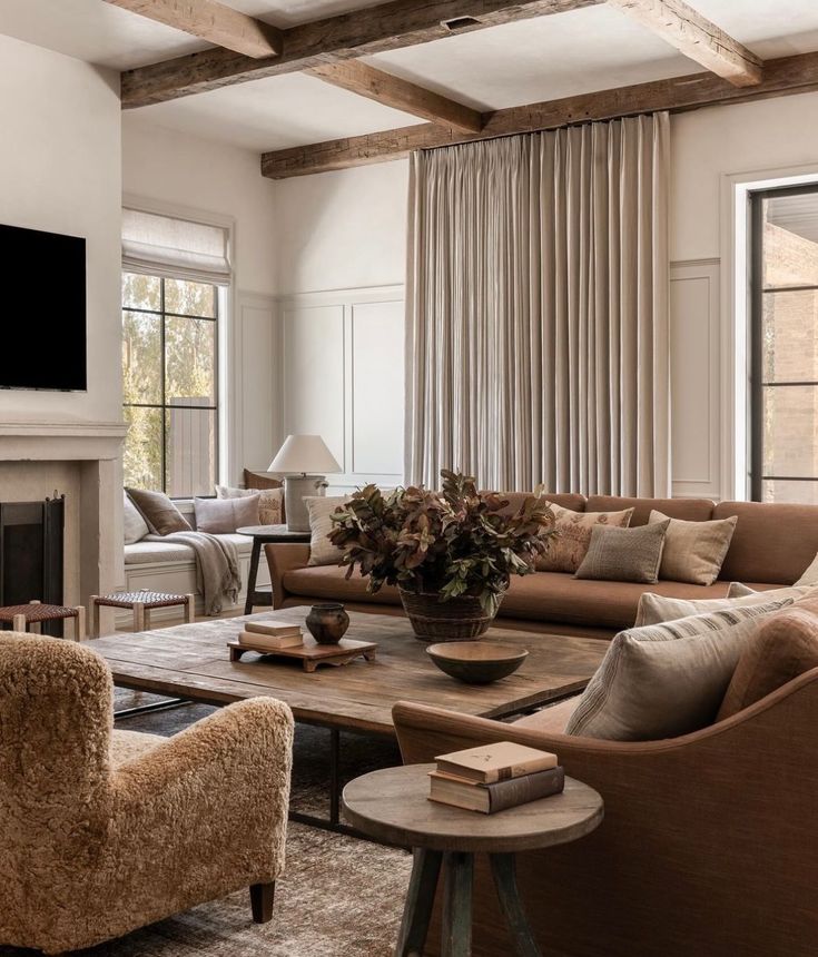 a living room filled with furniture and a flat screen tv mounted on the wall above a fireplace