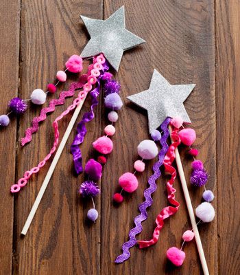 two stars and some pom poms on a wooden floor with sticks in the middle