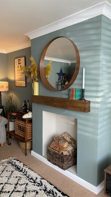 a living room filled with furniture and a fire place under a round mirror on the wall