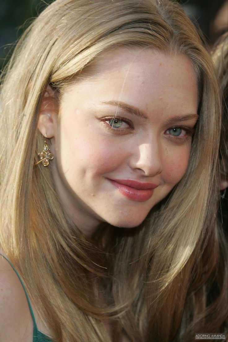 a woman with long blonde hair smiling at the camera