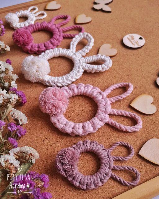 several crocheted hair accessories are laid out on a table with flowers and hearts