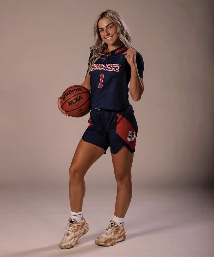 a woman holding a basketball and posing for a photo