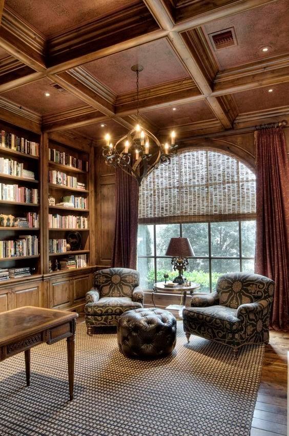 a living room filled with lots of furniture and bookshelves next to a window