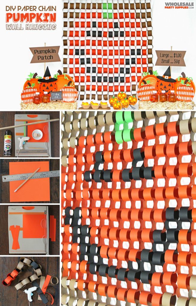 an orange and black pumpkin themed wall hanging on the side of a building with paper chains attached to it