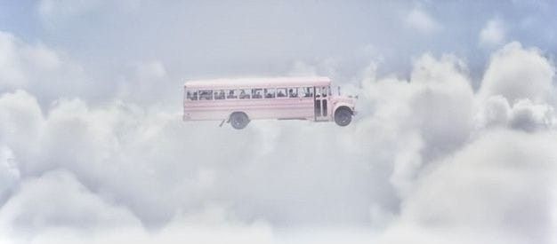 a pink bus is flying through the clouds