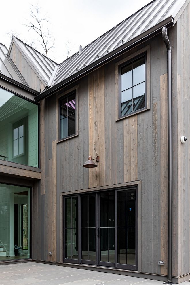 an exterior view of a modern home with wood siding and glass doors on both sides