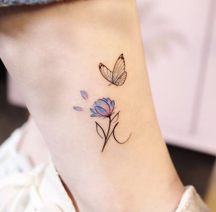 a small tattoo on the ankle of a woman's foot with flowers and butterflies