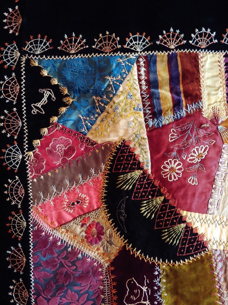 a close up of a patchwork quilt with many different colors and designs on it