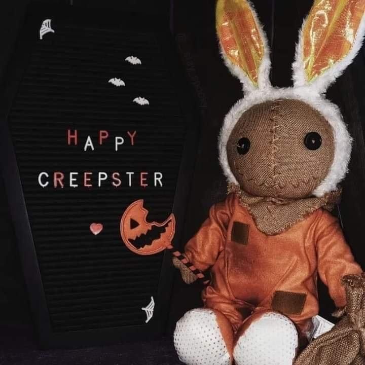 a stuffed rabbit is sitting next to a halloween greeting card that says happy crepster