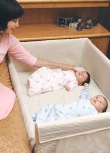 a woman is playing with her baby in the crib