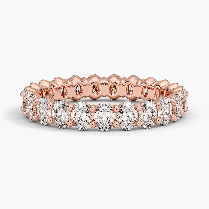 a rose gold and white diamond ring with rows of round diamonds on the side, set in