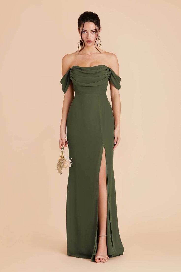 a woman wearing a green dress with an off the shoulder slit