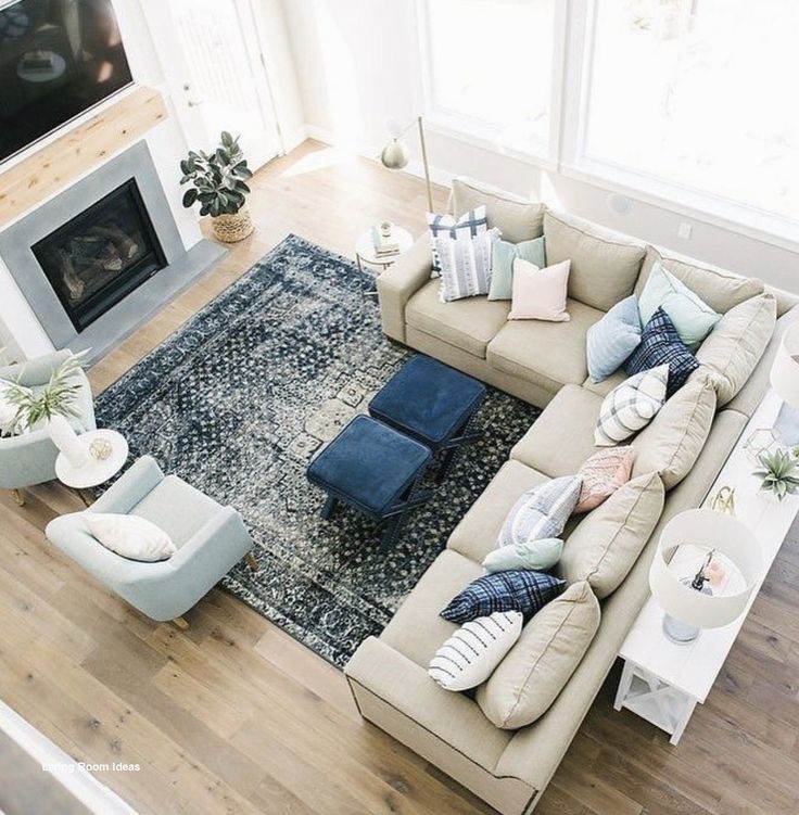 a living room filled with furniture and a large rug on top of a hard wood floor