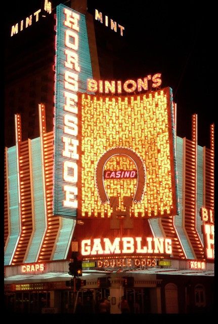 the neon sign for casino and gambling in las vegas, nv is lit up at night