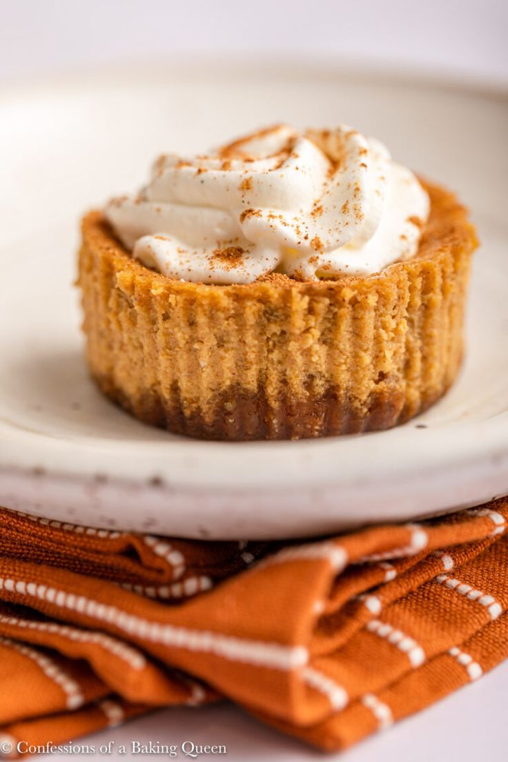 a small dessert on a white plate with a napkin and orange cloth next to it