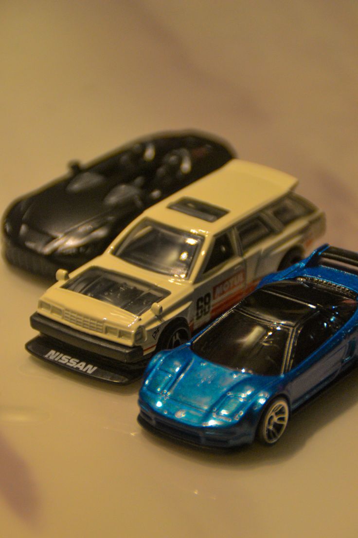 three toy cars sitting on top of a table