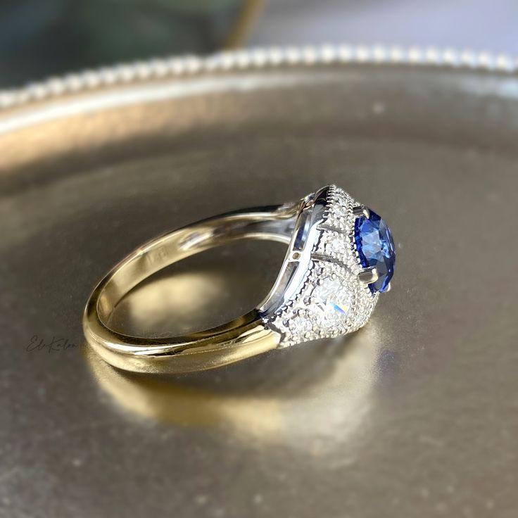 One piece of stunning, vintage-inspired Art Deco style 14K gold cornflower blue sapphire and diamond Ring Made to Order. Ships within 3-4 weeks. - Stone info: 6-6.5 x 5-5.5mm cushion cut natural blue sapphire various sizes of natural diamonds, round brilliant cut, G-H/SI quality - Total ct weight: approx. 1.55ctw - Finish: choice of two-tone, all white or all yellow - Made in 14 karat gold. - Stamp with 14K. Classic Blue Sapphire Ring With Diamond Accents, Blue Asscher Cut Diamond Ring With Accents, Heirloom Blue Sapphire Diamond Ring, Classic Blue Wedding Ring With Diamond Accents, Timeless Blue Cushion Cut Ring, Heirloom Blue Cushion Cut Rings, Blue Sapphire Ring With Diamond Accents, Asscher Cut, Blue Sapphire Ring With Cushion Cut, Blue Cushion Cut Sapphire Diamond Ring