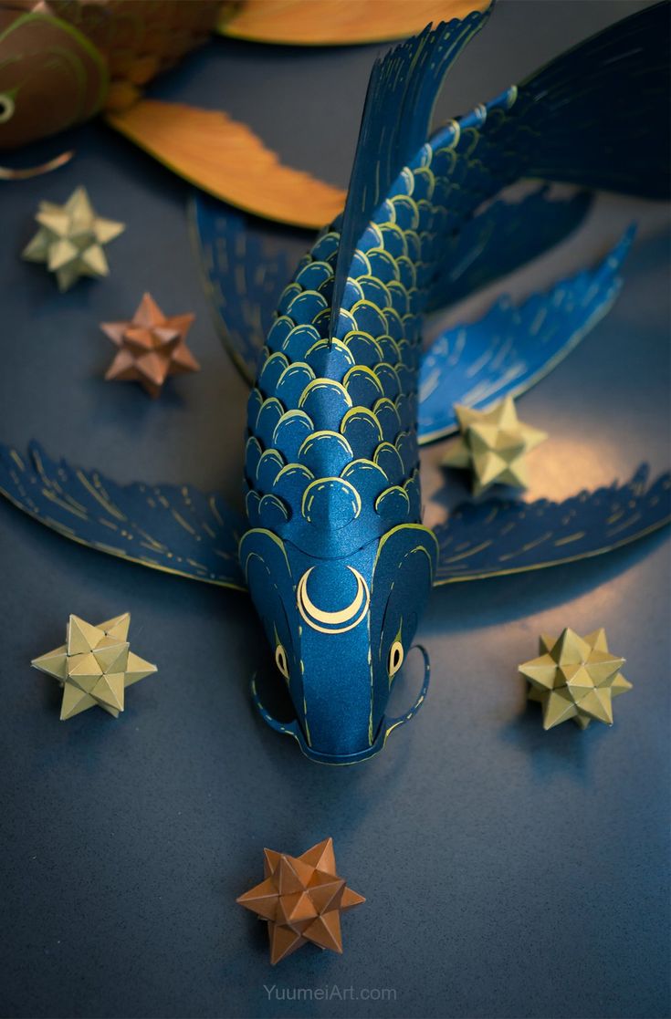 a blue paper fish with gold stars around it