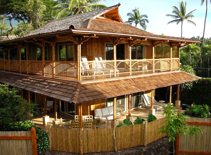 a large wooden house sitting on top of a lush green hillside