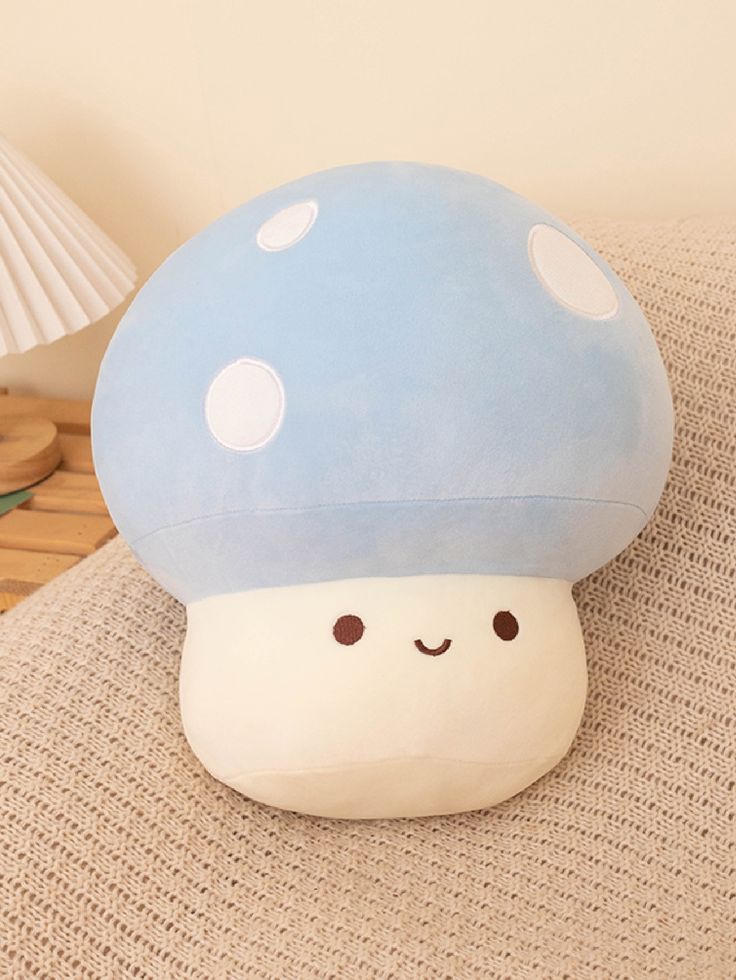 a blue mushroom pillow sitting on top of a couch