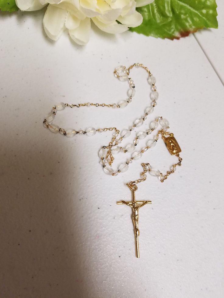 "Beautiful Vintage Rosary, new never been used in original clear box. Makes a perfect gift for Catholic Wedding couple, First Communion, Confirmation, Birthday. Dementions: Decades length: 18\" Complete folded rosary as shown laying on table including crucifix: 14\" Crucifix: 1 1/2\" x 7/8\" FINAL SALE, NO RETURNS, NO EXCHANGES, PLEASE CONTACT FOR ANY QUESTIONS OR CONCERNS AFTER LOOKING AT ALL THE PICTURES." Gold Cross Rosary For Wedding, Gold Wedding Rosary With Cross Shape, 8mm Bead Crucifix For First Communion, 8mm Bead Crucifix Jewelry For First Communion, Gold Rosary With Round Beads As Gift, Gold Round Beads Rosary As Gift, Wedding Rosary With Crucifix Spiritual Style, Spiritual Wedding Rosary With Crucifix, Adjustable Rosary With Miraculous Medal Gift